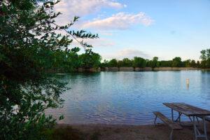 Island Lake Recreation Area swimming lake and park bench in Brighton, Michigan