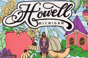 girl standing in front of Howell mural