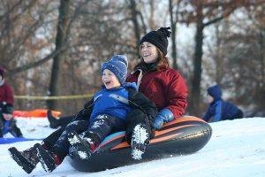 A mother and son sledding down a hill