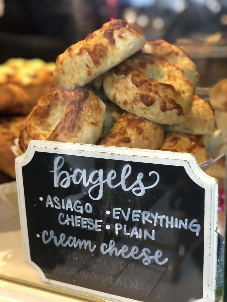 A stack of bagels with a sign in front of it