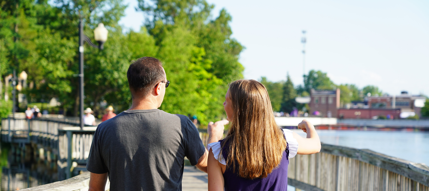 Father and daughter walk along bridge downtown brighton