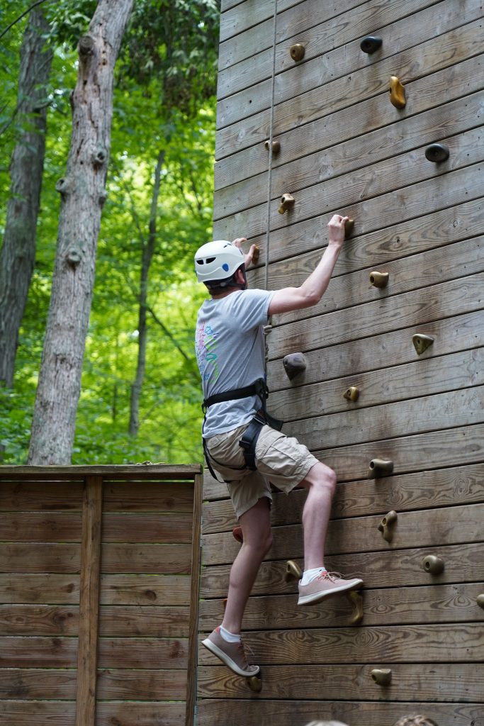 man climbs rock wall