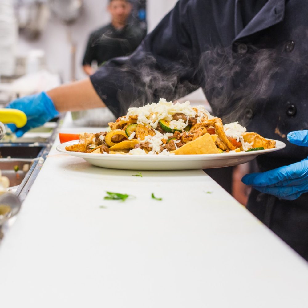 Cooks prepare tacos