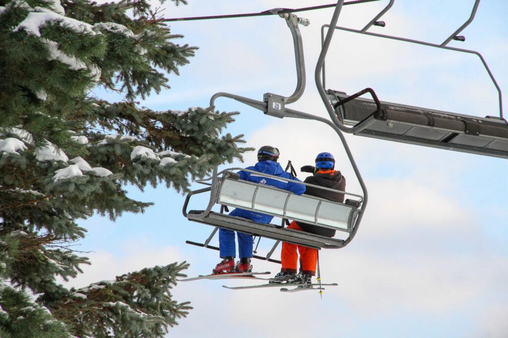 two people on a chair lift on a snowy day at Mt. Brighton in Brighton, MI