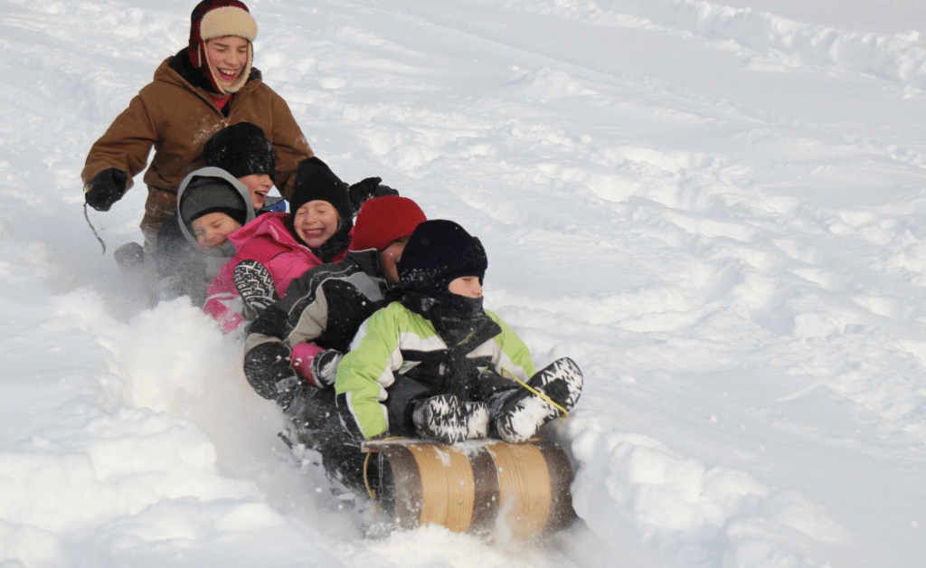 kids sledding on a snowy day