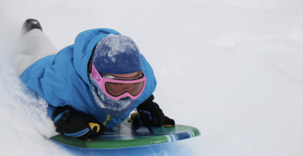 person sledding down a snowy hill