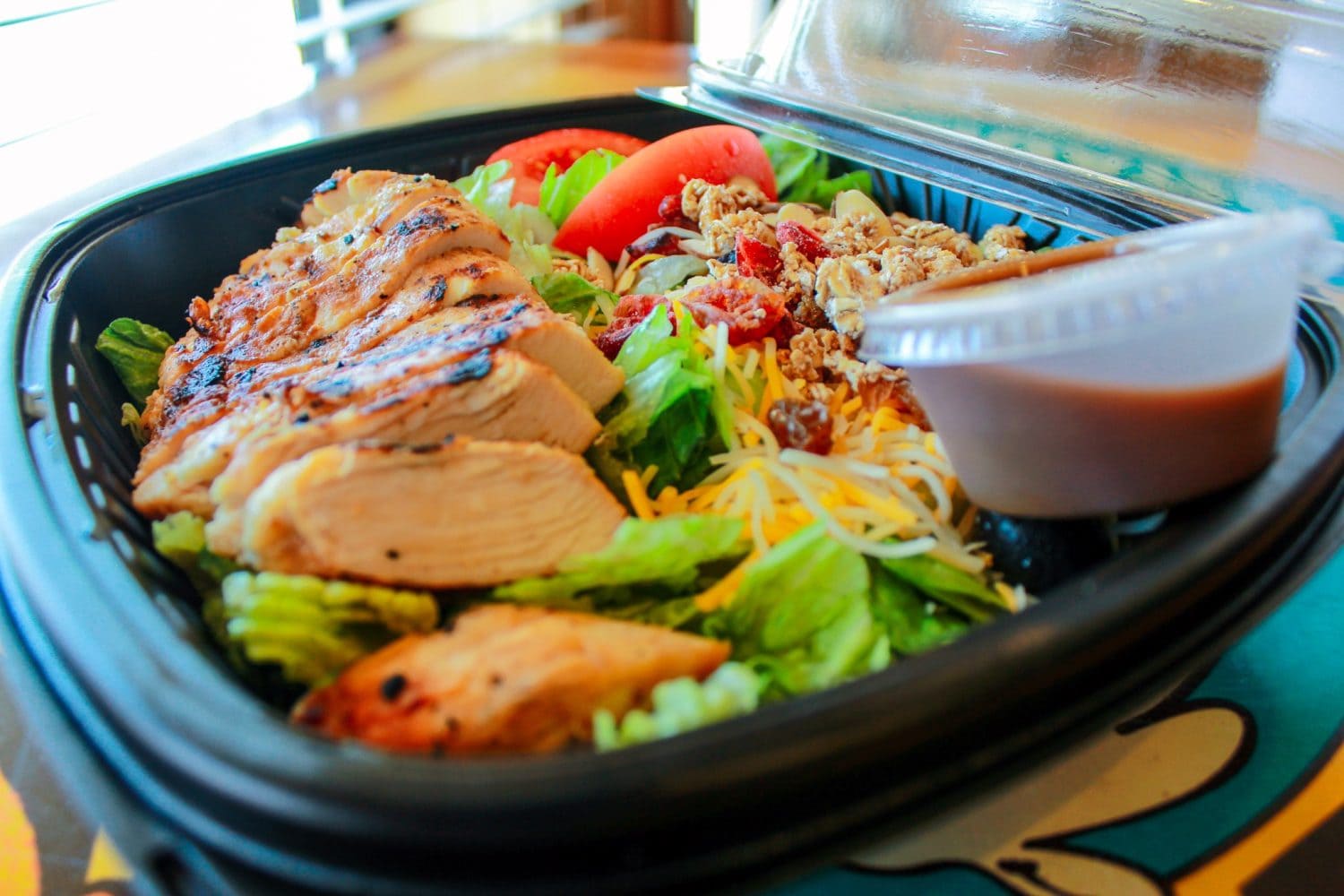 Close up photo of a berry almond salad topped with chicken