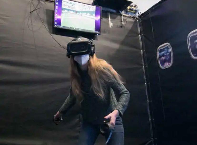 Person playing virtual reality game in arcade