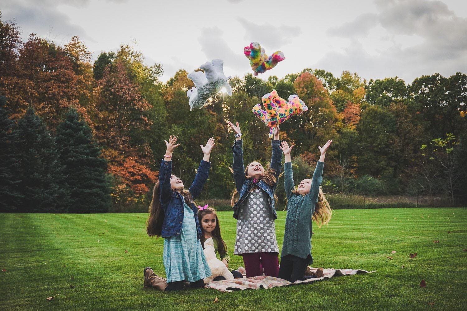 kids throwing stuffed animals in the air