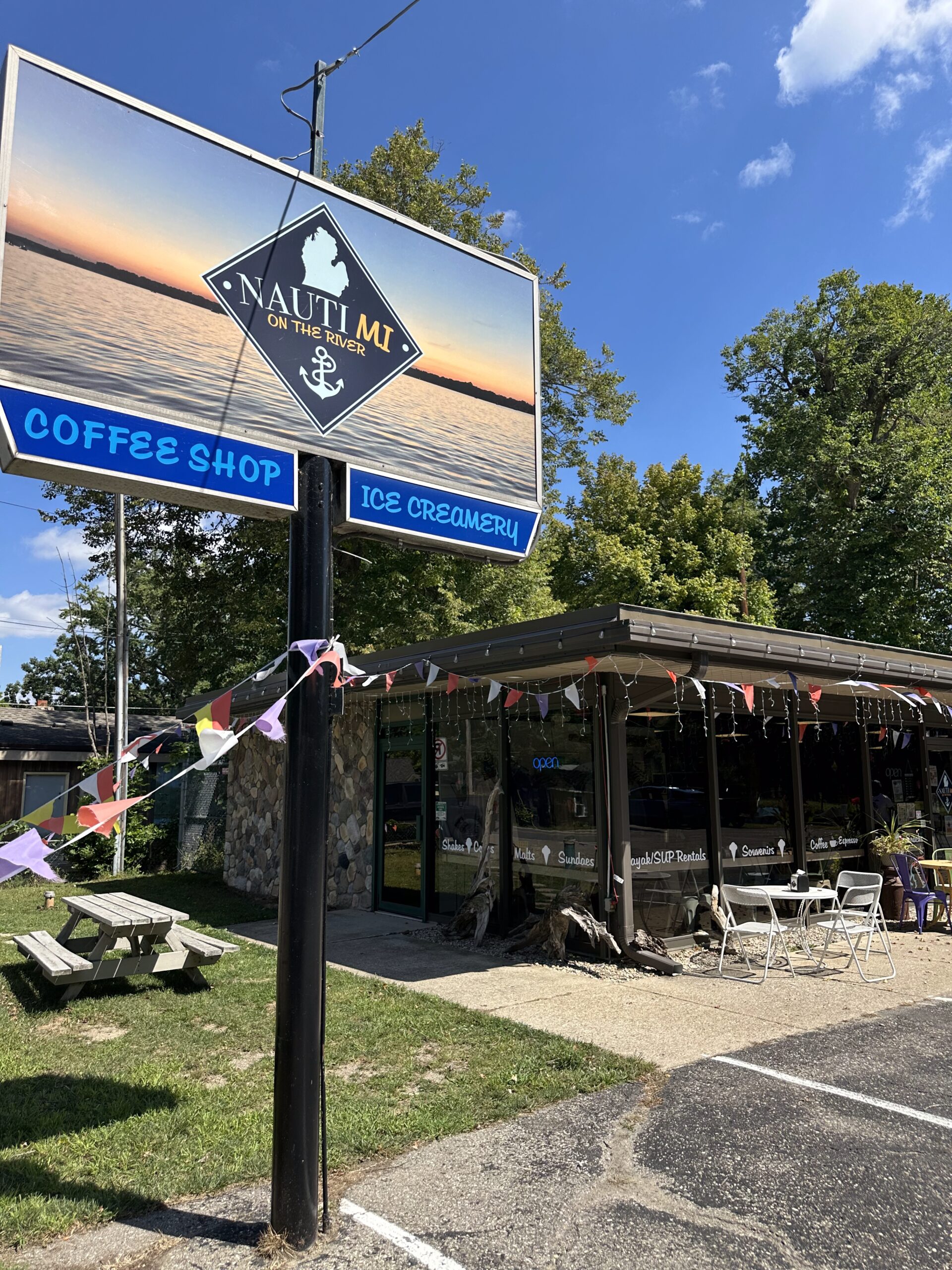 NautiMi on the River exterior of store with big sign on sunny day in Pinckney.