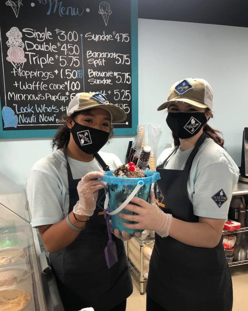 two employees holding ice cream bucket