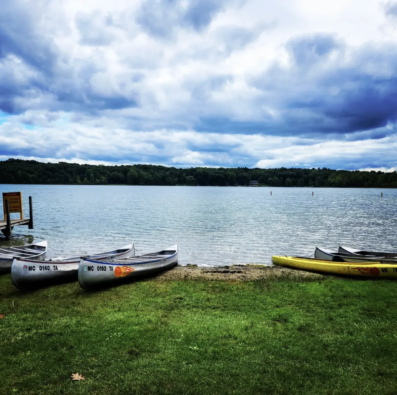 Hell Canoe and Kayak Rentals canoe on shoreline on cloudy day in Pinckney.
