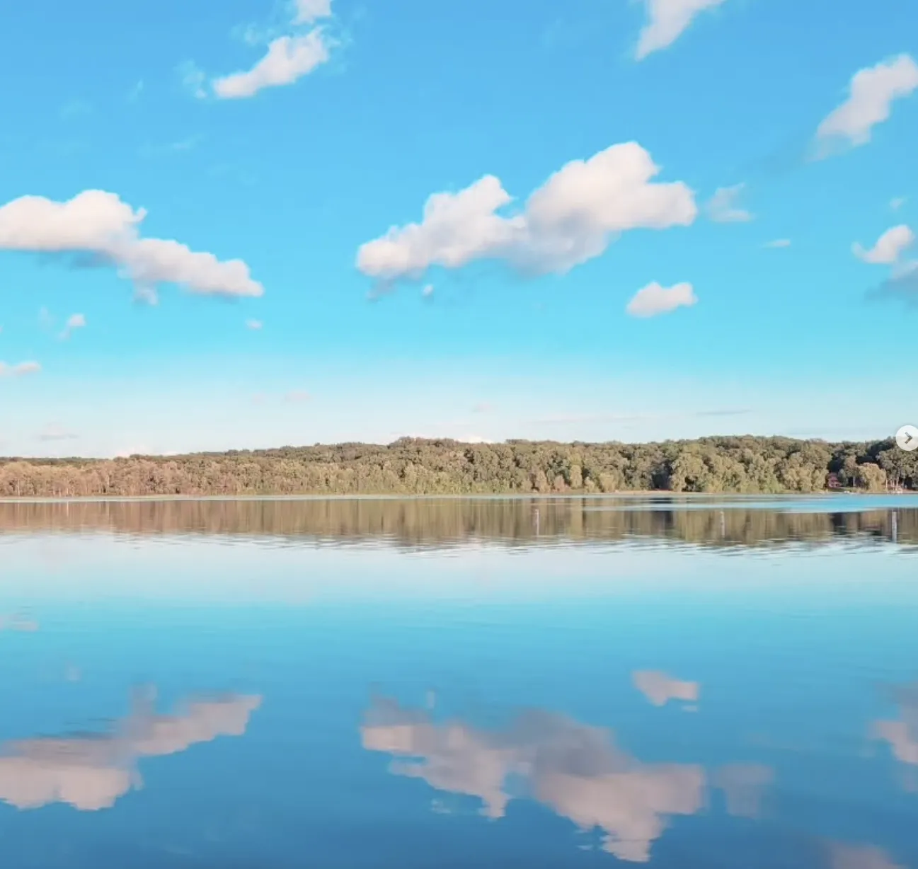 Hell Canoe and Kayak Rentals view of lake on sunny day with blue sky and water.