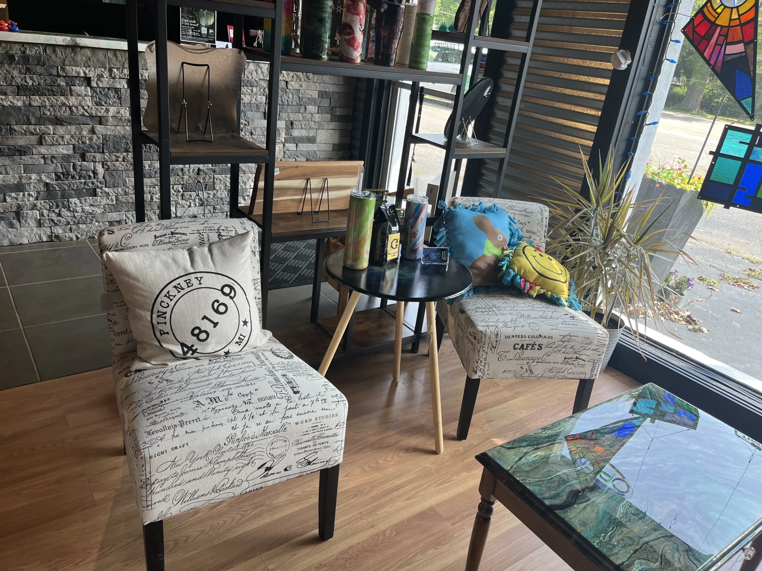 Display at Bark Art Creations with chairs and resin work on table.
