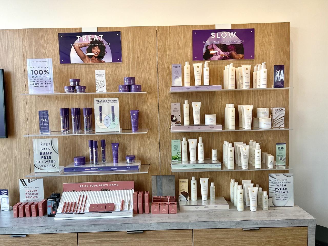 bottles and lotions displayed on shelves with advertisements surrounding them. beauty products for European wax center.