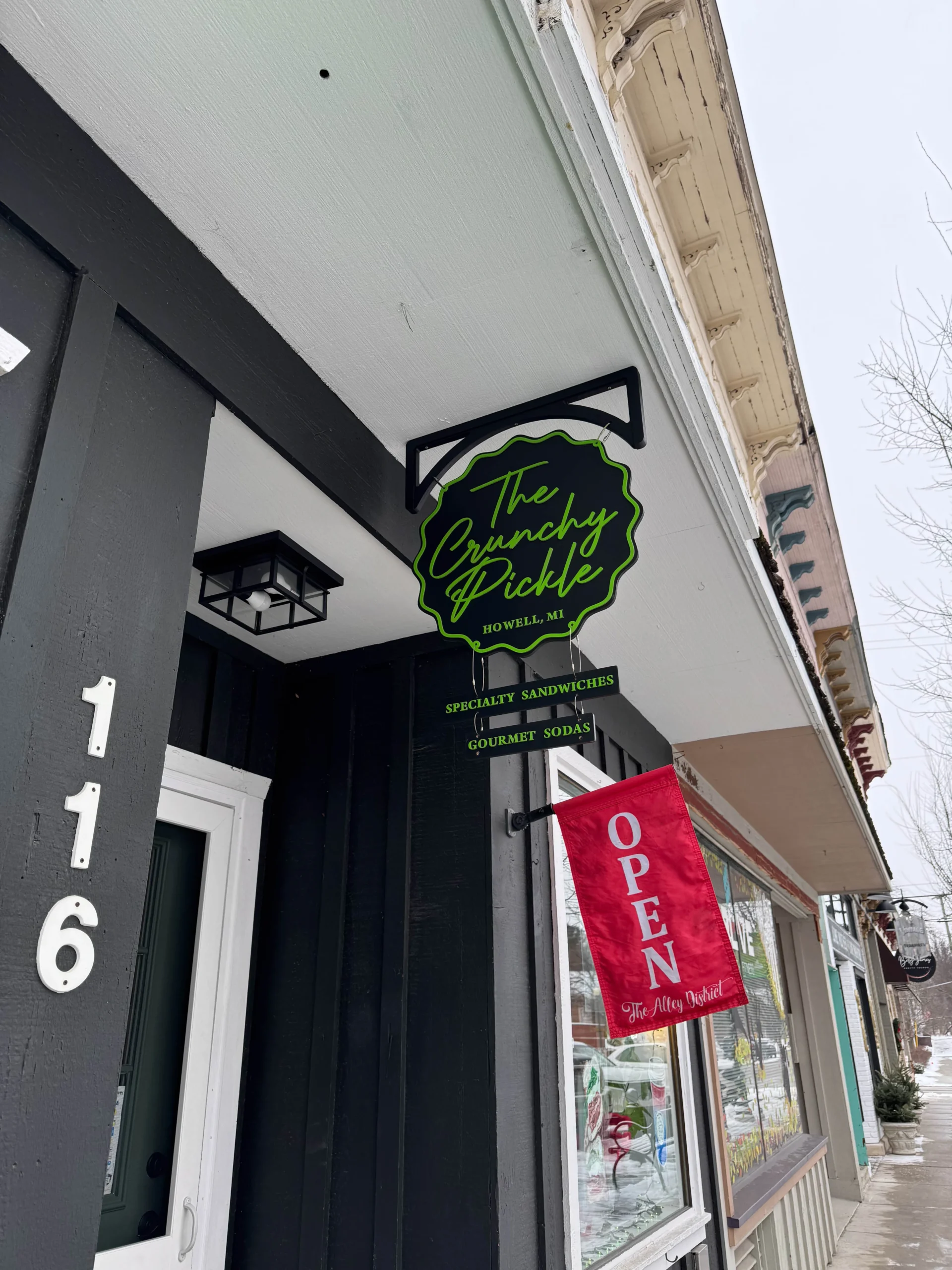 The Crunchy Pickle entrance to shop with open sign in Howell