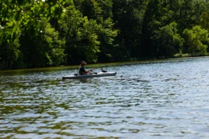 man kayaking at Bishop Lake in Brighton Recreation Area