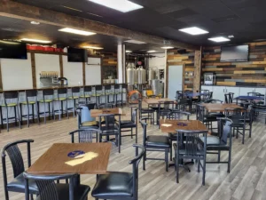 Full Circle Brews bar and seating area tap room with tables and chairs.