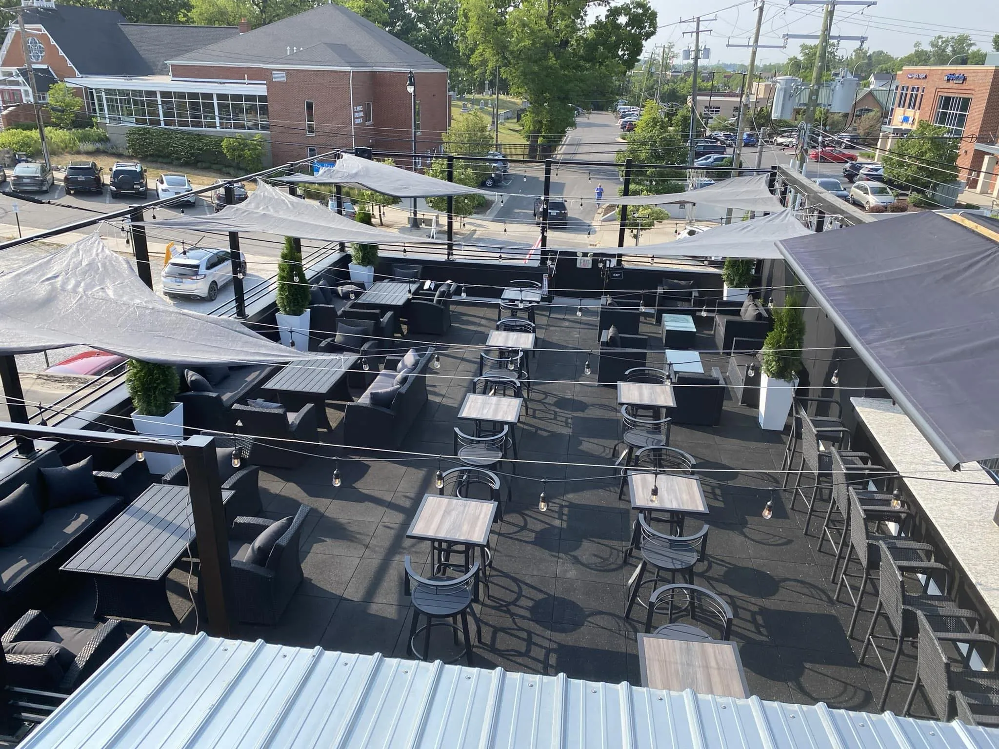 Rooftop view of 120 West with tables, chairs, and umbrellas.