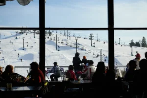 ORE CREEK MOUNTAIN GRILL restaurant in Brighton with window view of the mountan with skiiers