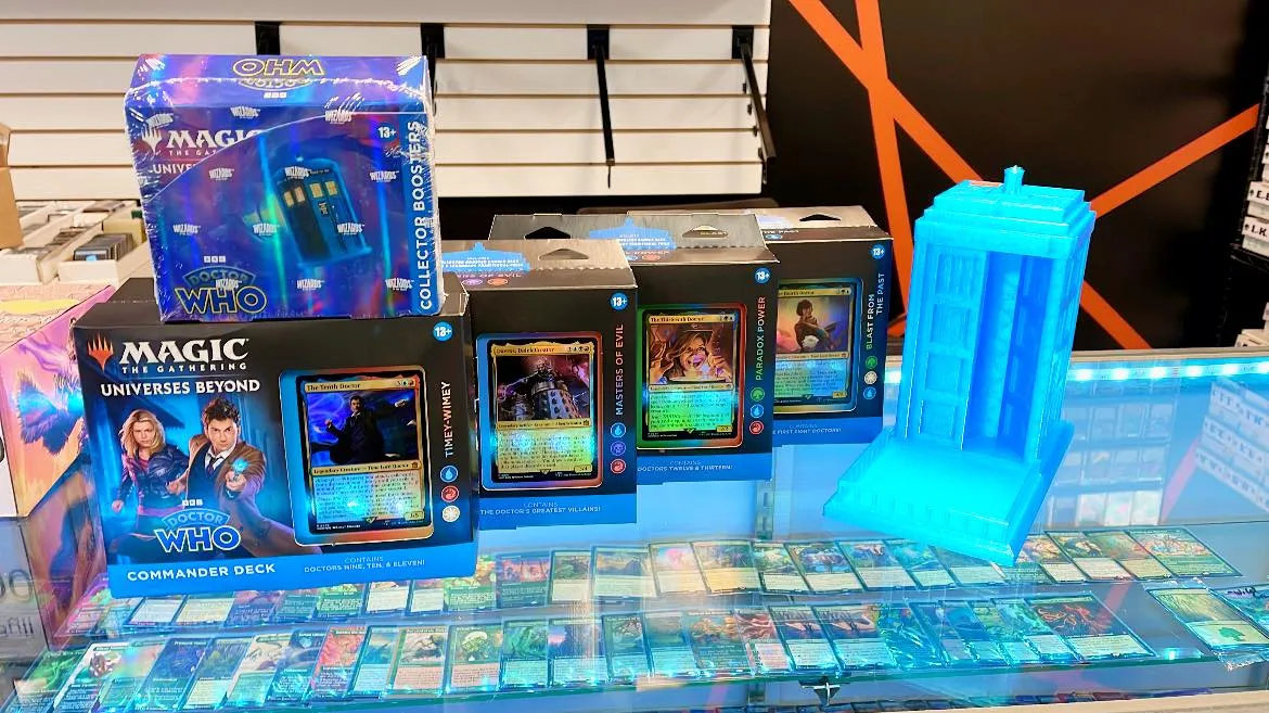 Moms Basement Games cards displayed with blue light on countertop in gaming store.
