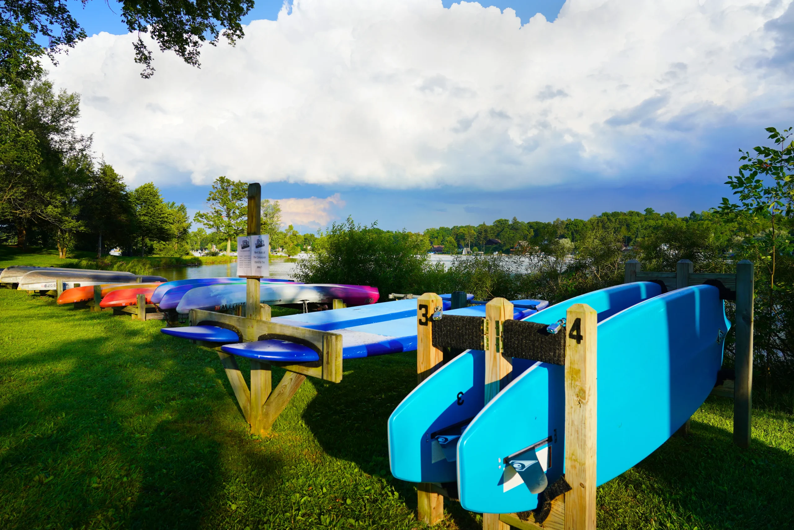 kayaks and stand up paddle boards on the shore of Silver Lake in the PInckney Recreation Area