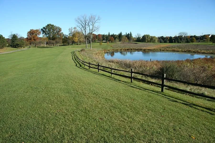 huron meadows metropark golf course grass and water view on sunny day.