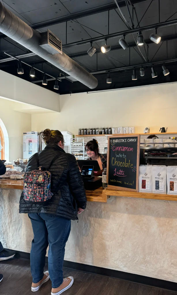 A woman ordering at the counter of the Brighton Coffeehouse and theatre