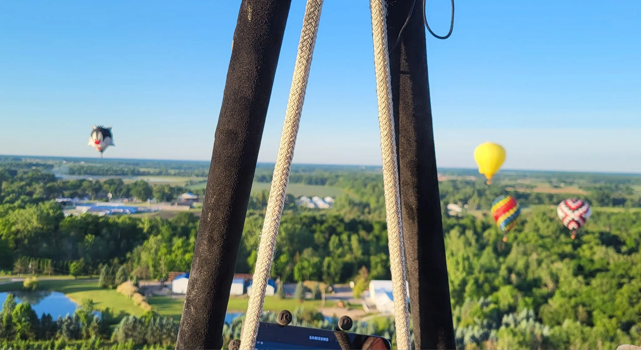 Majestic Adventures Hot Air Ballooning view from inside basket on sunny day of land below.