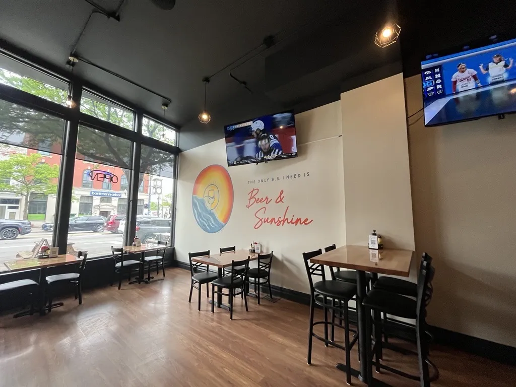 SunnySips Bar & Grill indoor dining area with BS mural