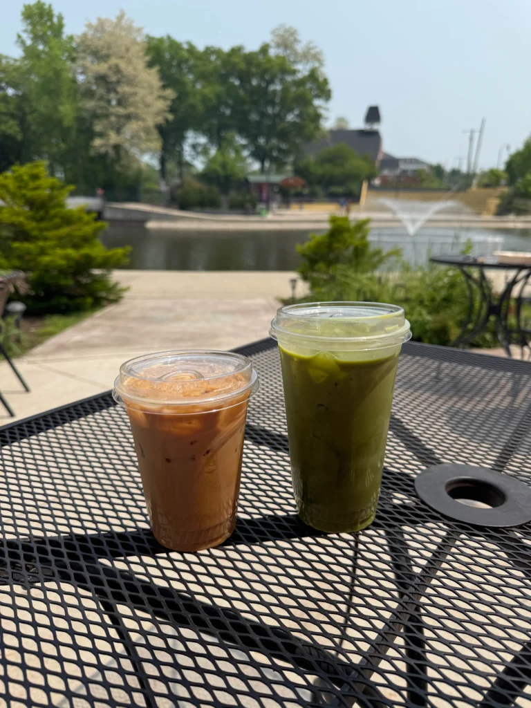 An iced latte and matcha on a table on the Brighton Coffeehouse and theater's patio.
