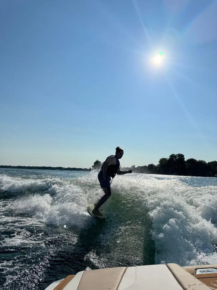 Surf Republic Whitmore Lake view of surfer beind the boat surfing.