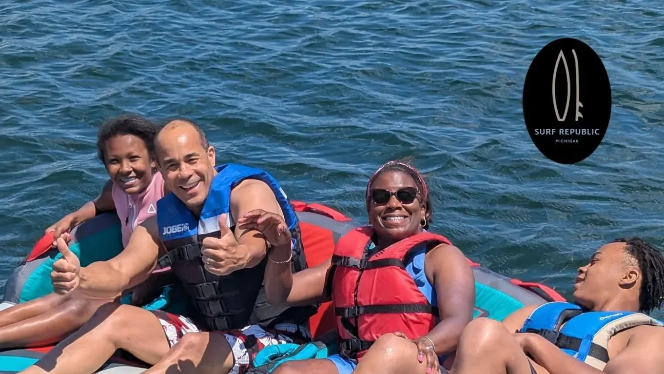 Surf Republic goup of people smiling on tube in Whitmore Lake.